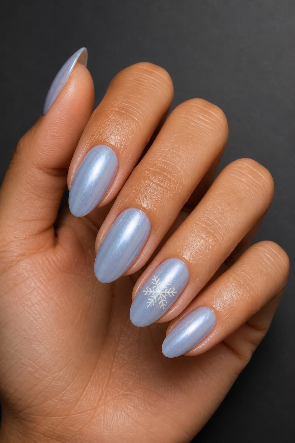 Medium almond Christmas nails with icy blue pearl polish and one delicate white snowflake accent.