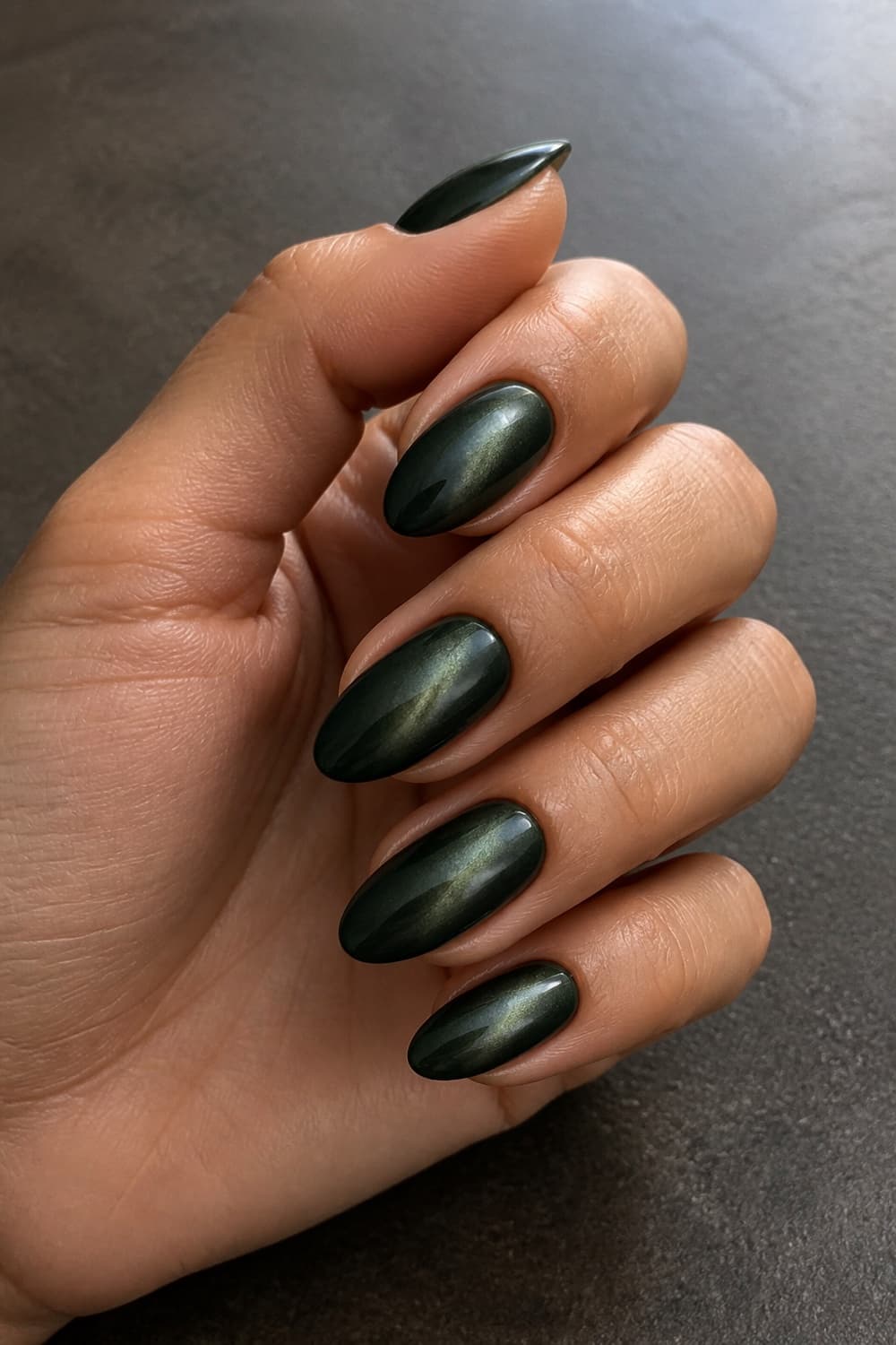 Forest green velvet almond nails with a soft magnetic shimmer