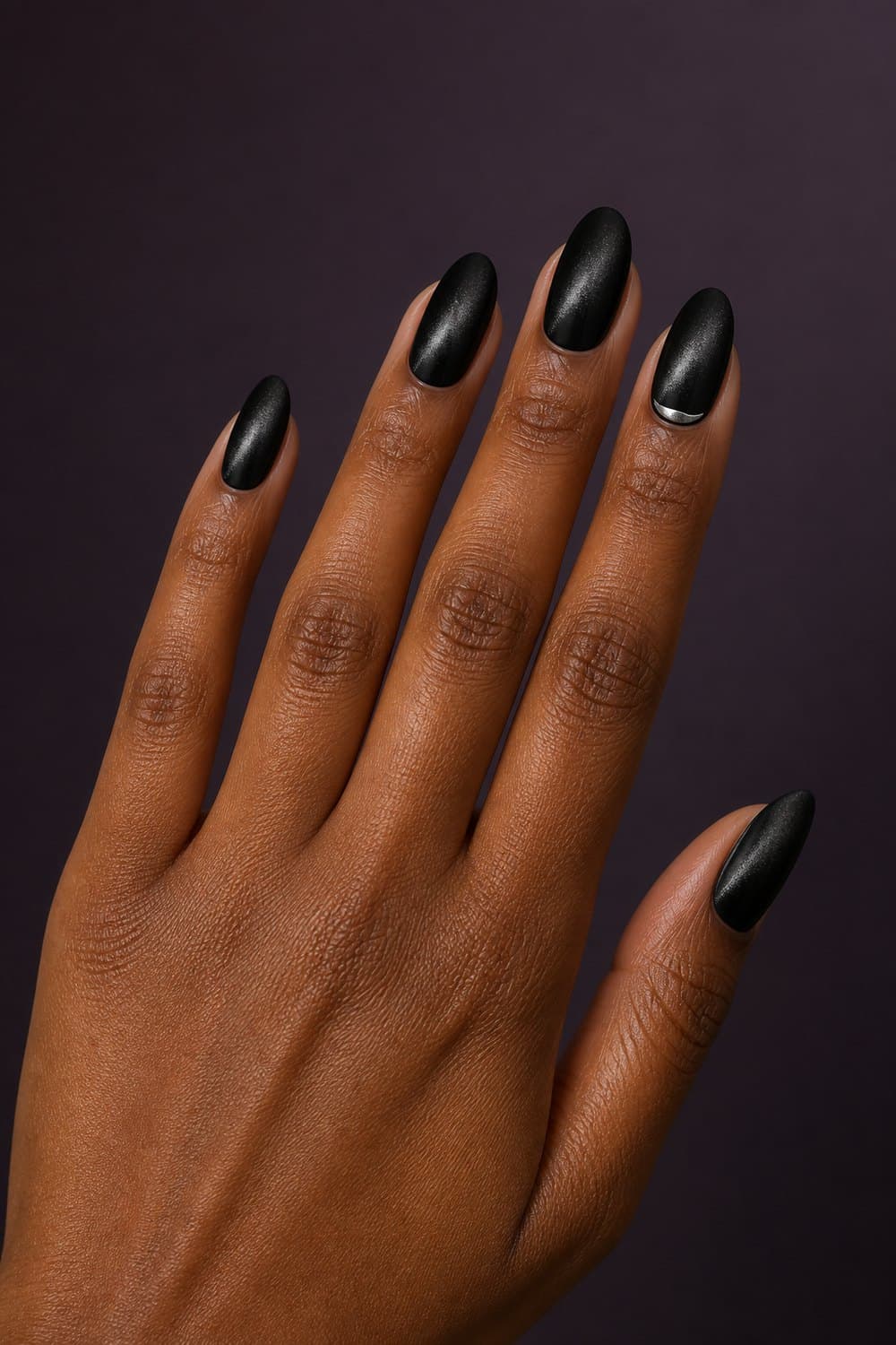 Black velvet almond nails with a restrained silver crescent accent for Halloween 2026