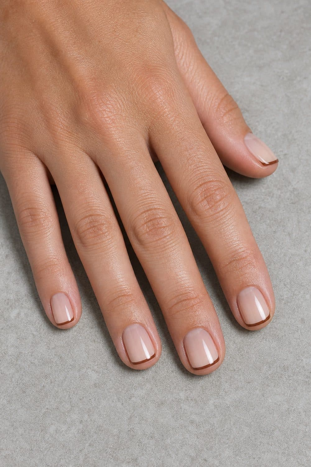 Short square nails with a sheer cream base and pecan-brown micro French tips for Thanksgiving