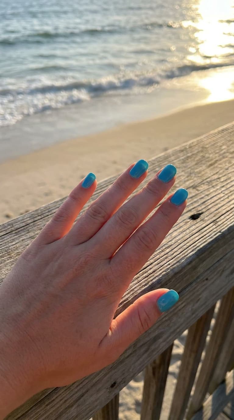 Ocean blue nail tips on female hand, beach nails for summer